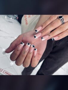 French Nails mit schwarzem Stern auf dem weißen Part.